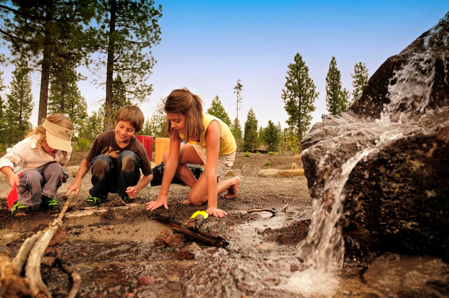 Kids Dig the Dirt - Discovery Park Playground and Sport Courts - With outdoor play areas for the whole family, everyone can enjoy their favorite pastimes. Do your little ones love to climb, swing, dig and experiment? Discovery Park is the perfect place for their imaginations to blosom. Situated next to the Quarry Pool and Fitness Center and overlooking Obsidian Lake, it is a beautiful place to play. Discovery Park is a unique combination of learning and playing. The park features life sized musical instruments, a climbing rock for daring little climbers, an interactive stream and waterway system, just perfect for building and exploring with nature, and high-flying swings. You can also enjoy the sport courts for tennis, pickle ball, and basketball. Shoot some hoops in your free time. The basketball court is located next to the Quarry Pool and Fitness Center.