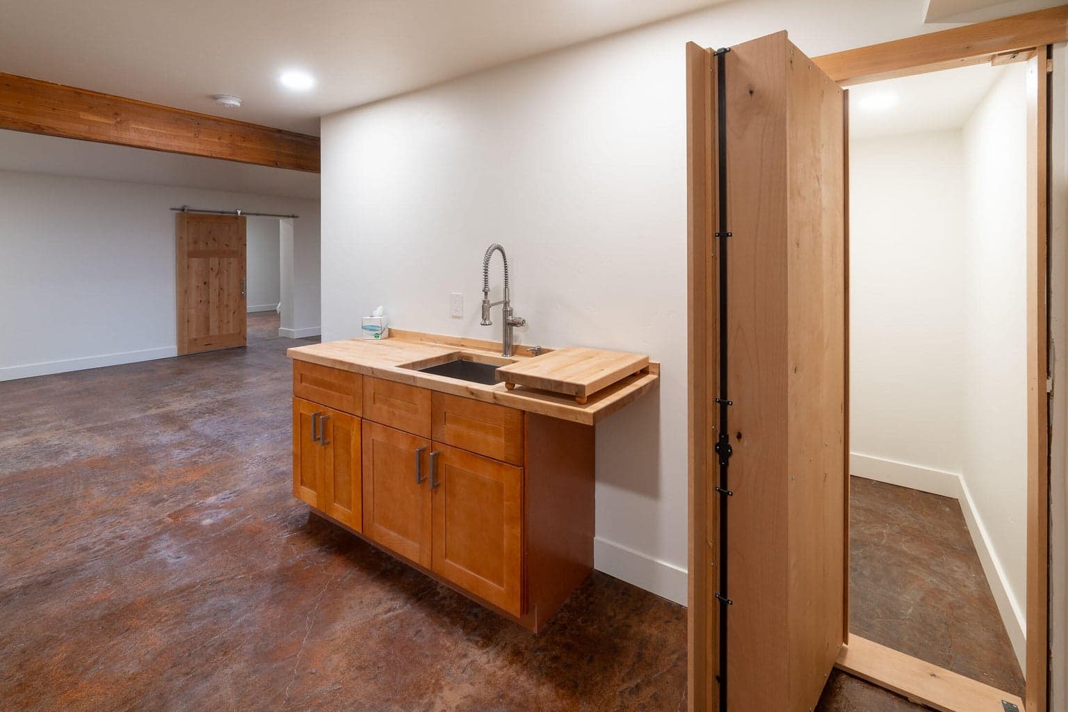 wet bar in basement with hidden room