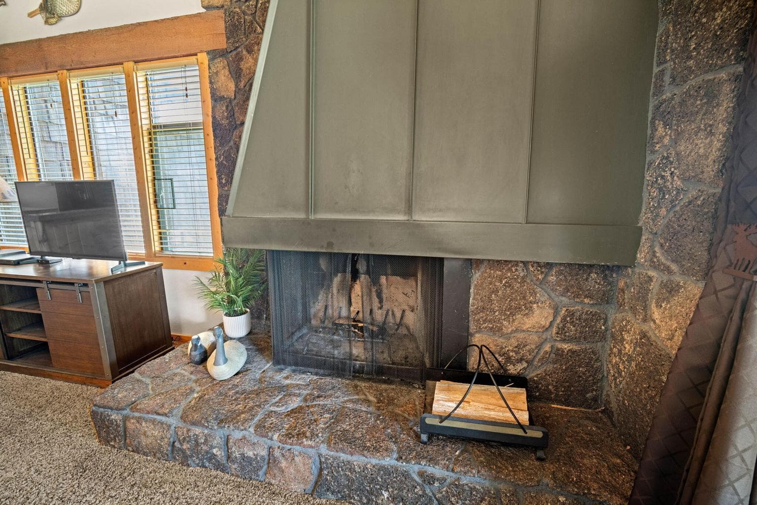 Floor to ceiling natural native lava rock wood burning fireplace