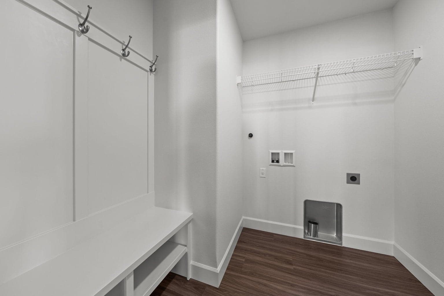 Laundry room/mud room features built-in bench with hooks and shelves