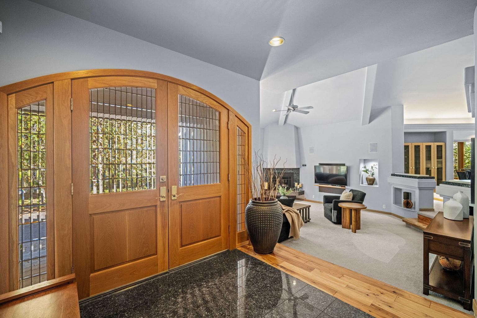 Artfully designed double doors with beveled glass open onto a spacious tile and hardwood entry