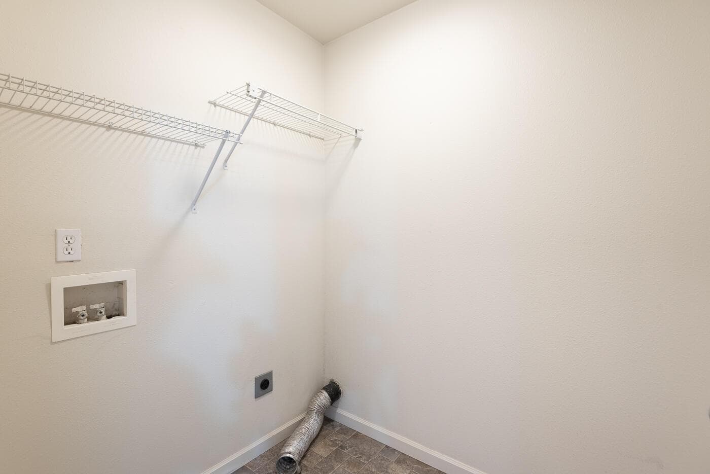 Upstairs laundry room with space for additional shelving or laundry baskets.