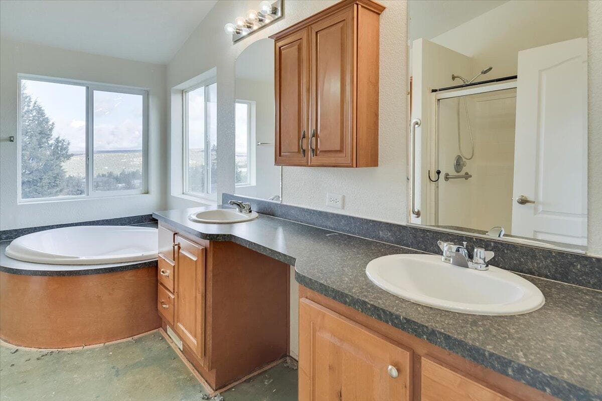 Primary bathroom with dual vanity and large soaking tub.