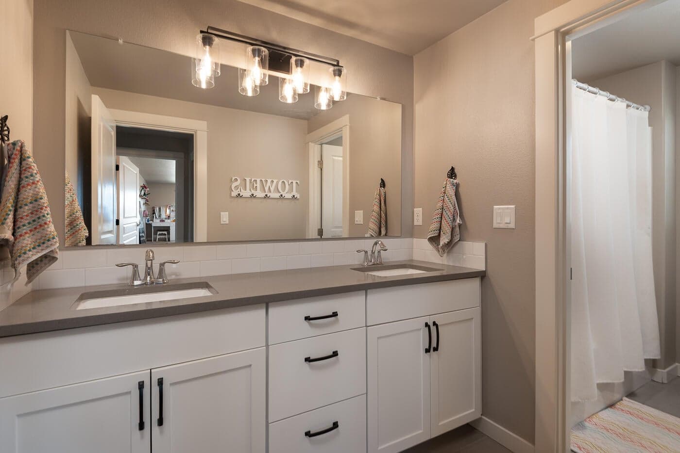 Upstairs bathroom with dual vanity. Toilet and shower/bath combo behind door.