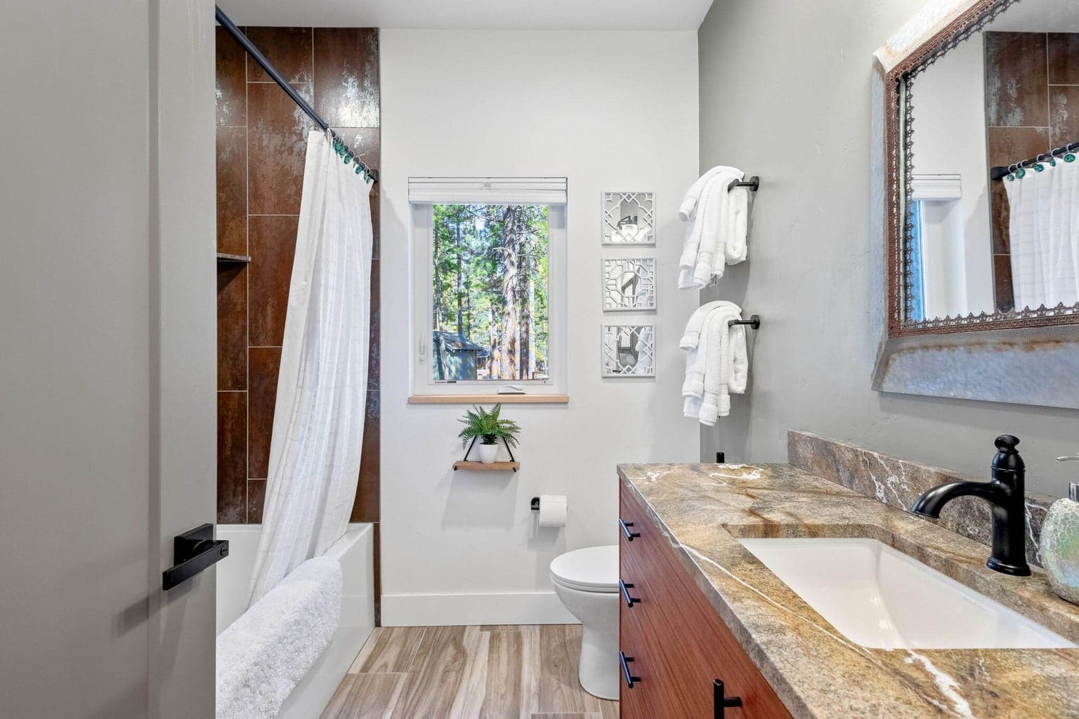 Lovely guest bath with stone vanity and tiled shower