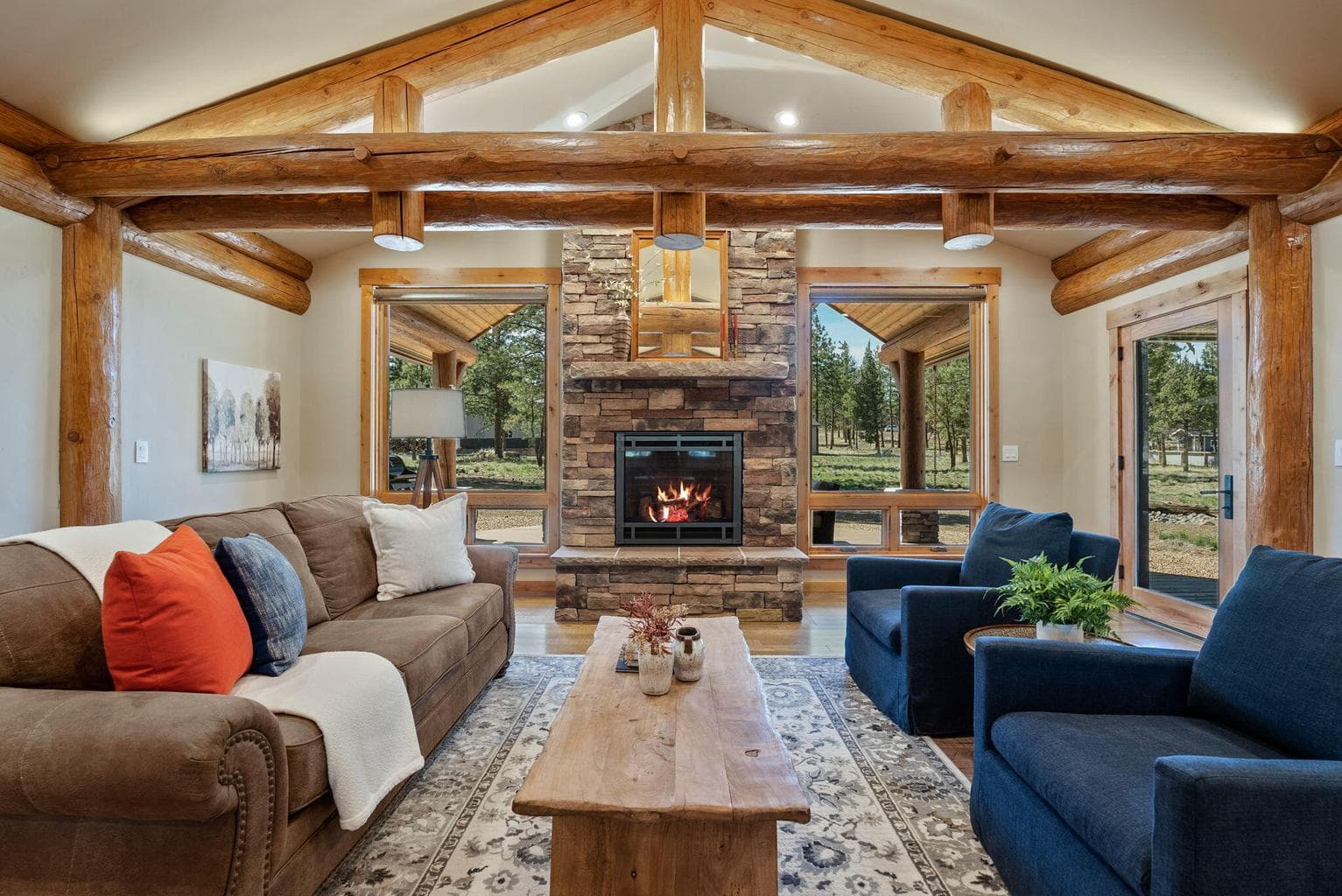 Great room features hickory hardwood floors, log-beam vaulted ceilings, propane fireplace with stone surround & limestone mantle, and more!