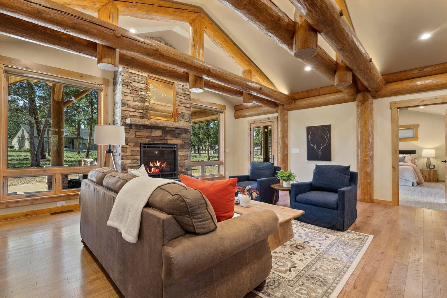 Great room features hickory hardwood floors, log-beam vaulted ceilings, propane fireplace with stone surround & limestone mantle, and more!