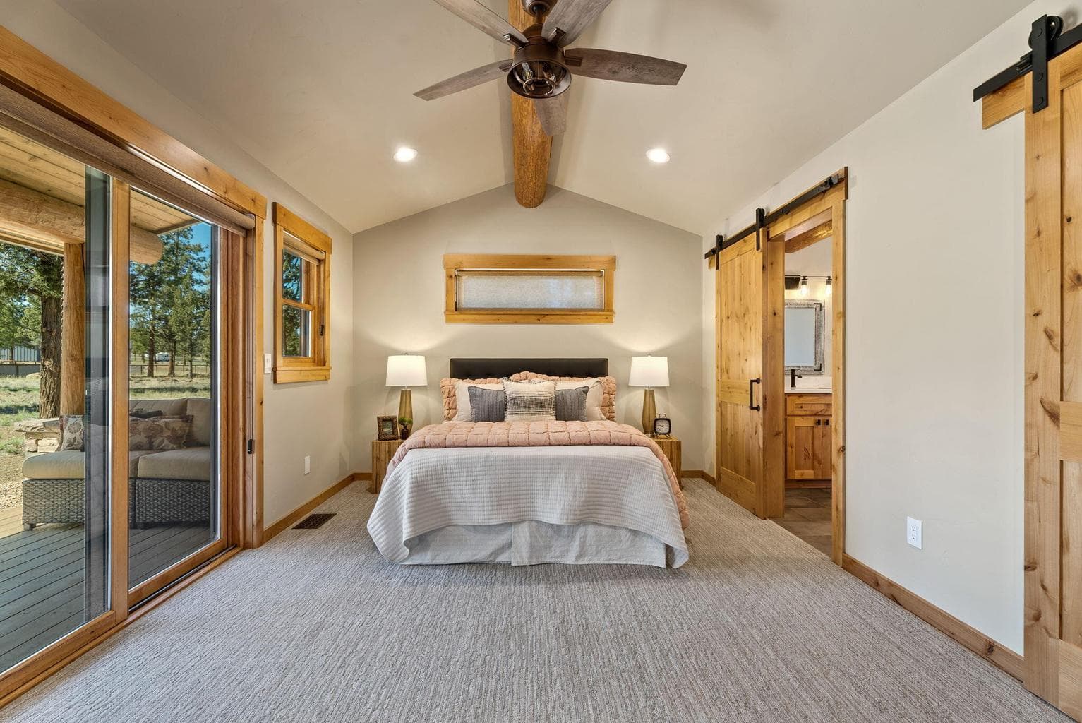 Primary ensuite features vaulted, log-beam ceiling, large walk-in closet, and outdoor living area.