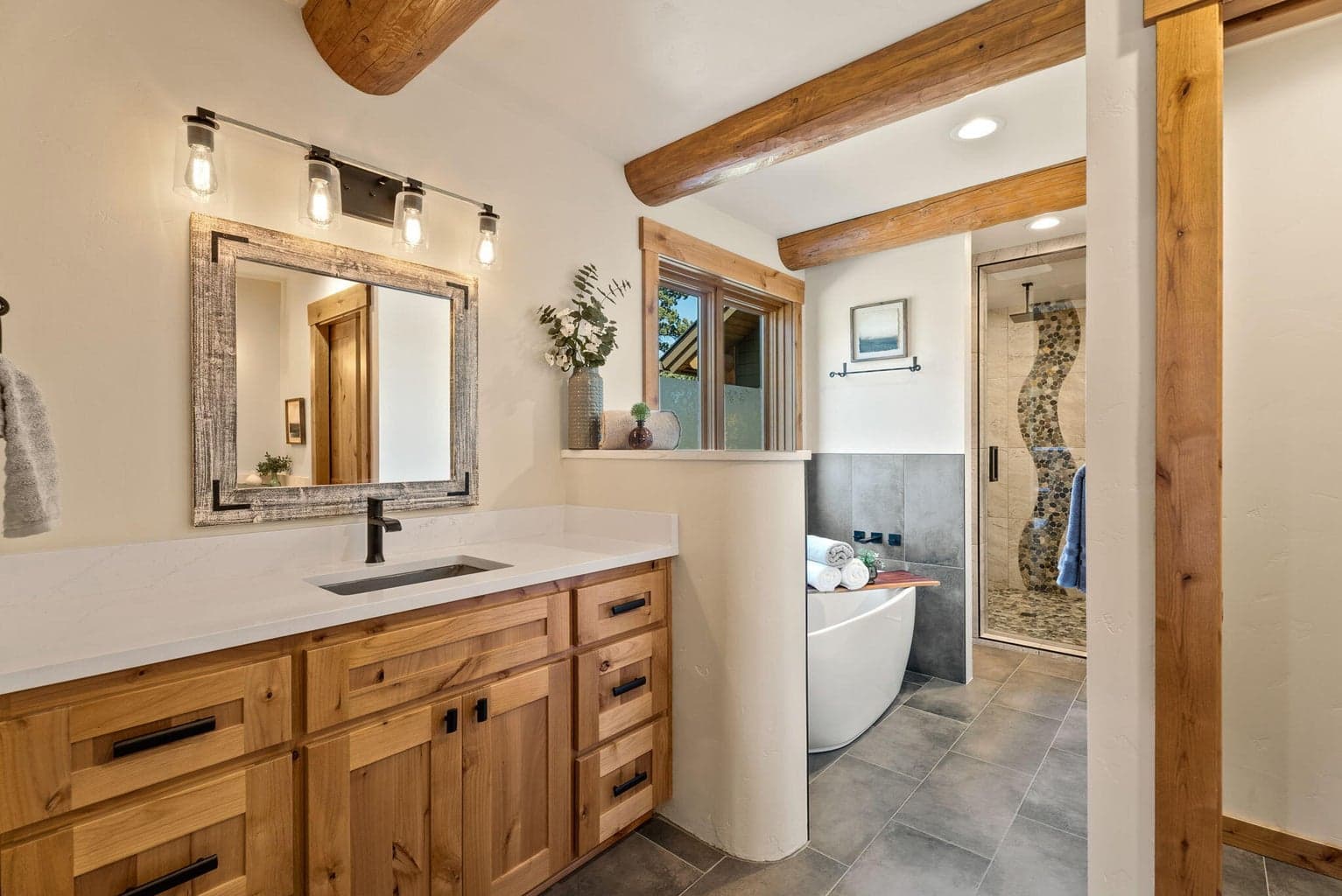 Primary ensuite bath features radiant heat tiled flooring, two solid surface vanities, soaking tub, plus glass door walk-in tiled shower.