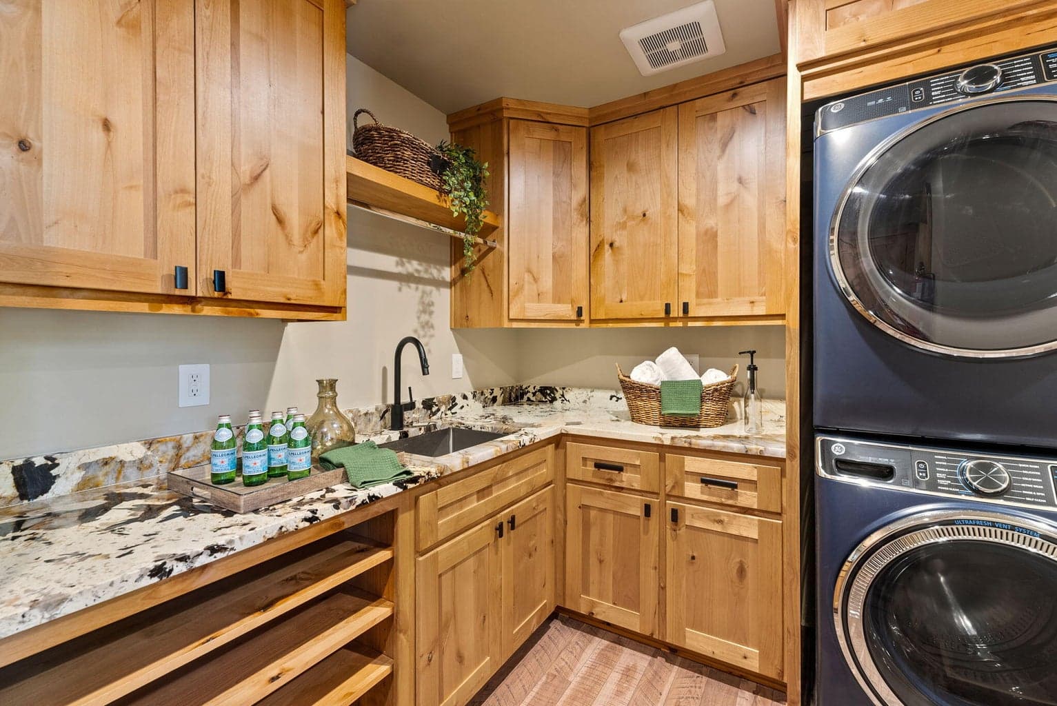 Butler pantry off the kitchen features hardwood floors, knotty alder cabinets, granite counters, sink, storage, washer/dryer, and more.