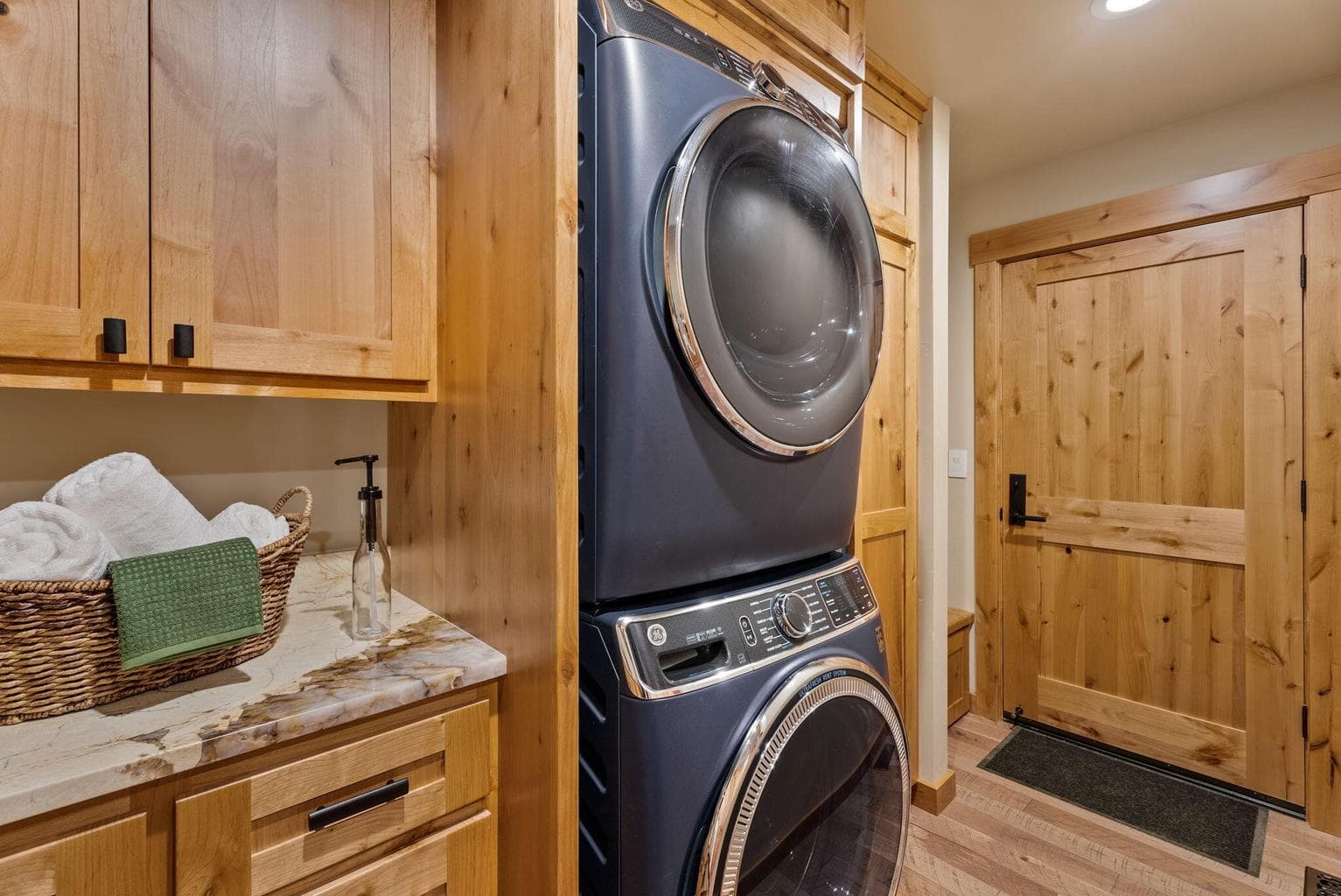 Butler pantry off the kitchen features hardwood floors, knotty alder cabinets, granite counters, sink, storage, washer/dryer, access to garage, and more.