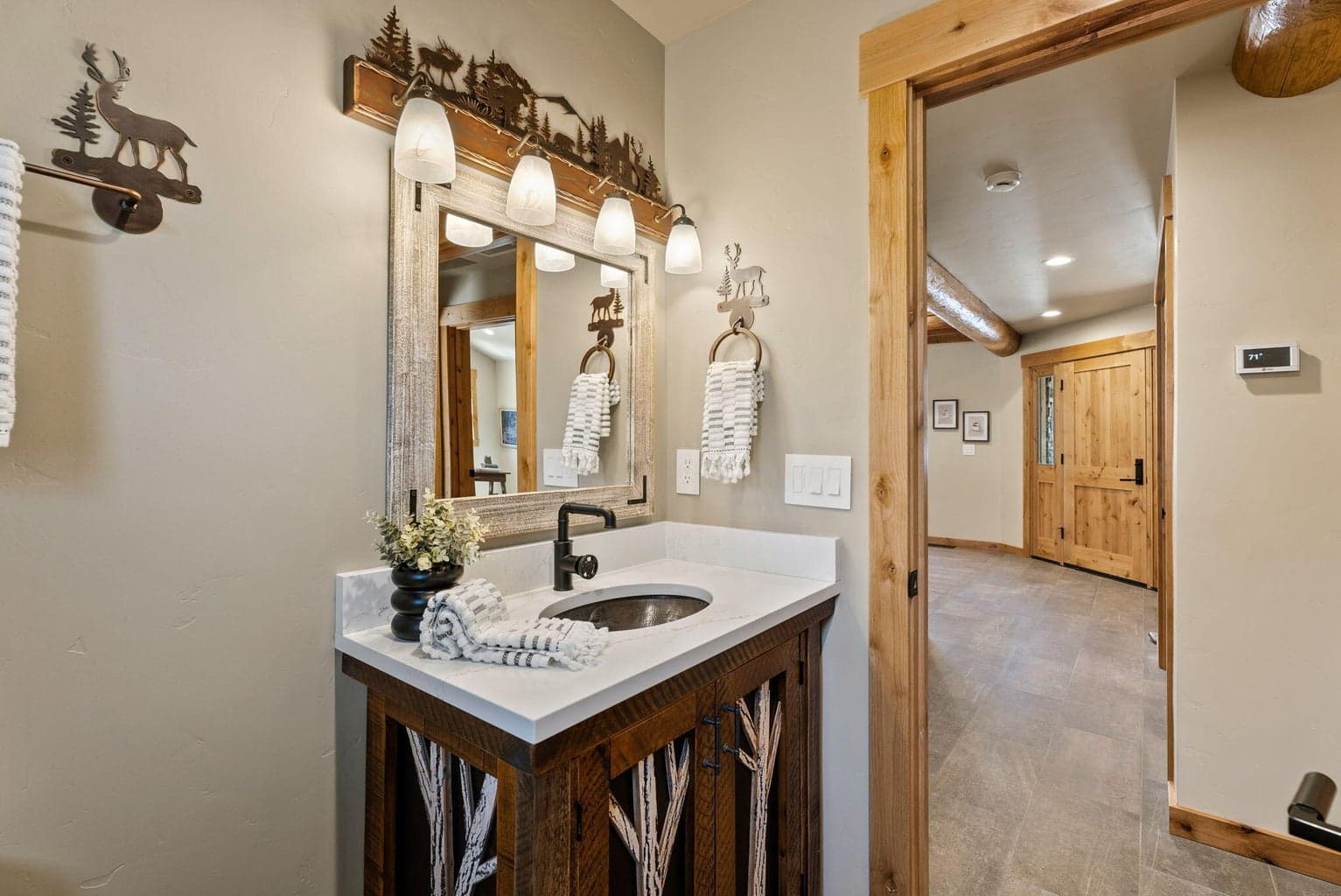 Guest bath features tiled flooring, tiled shower surround, and a single vanity with copper sink.