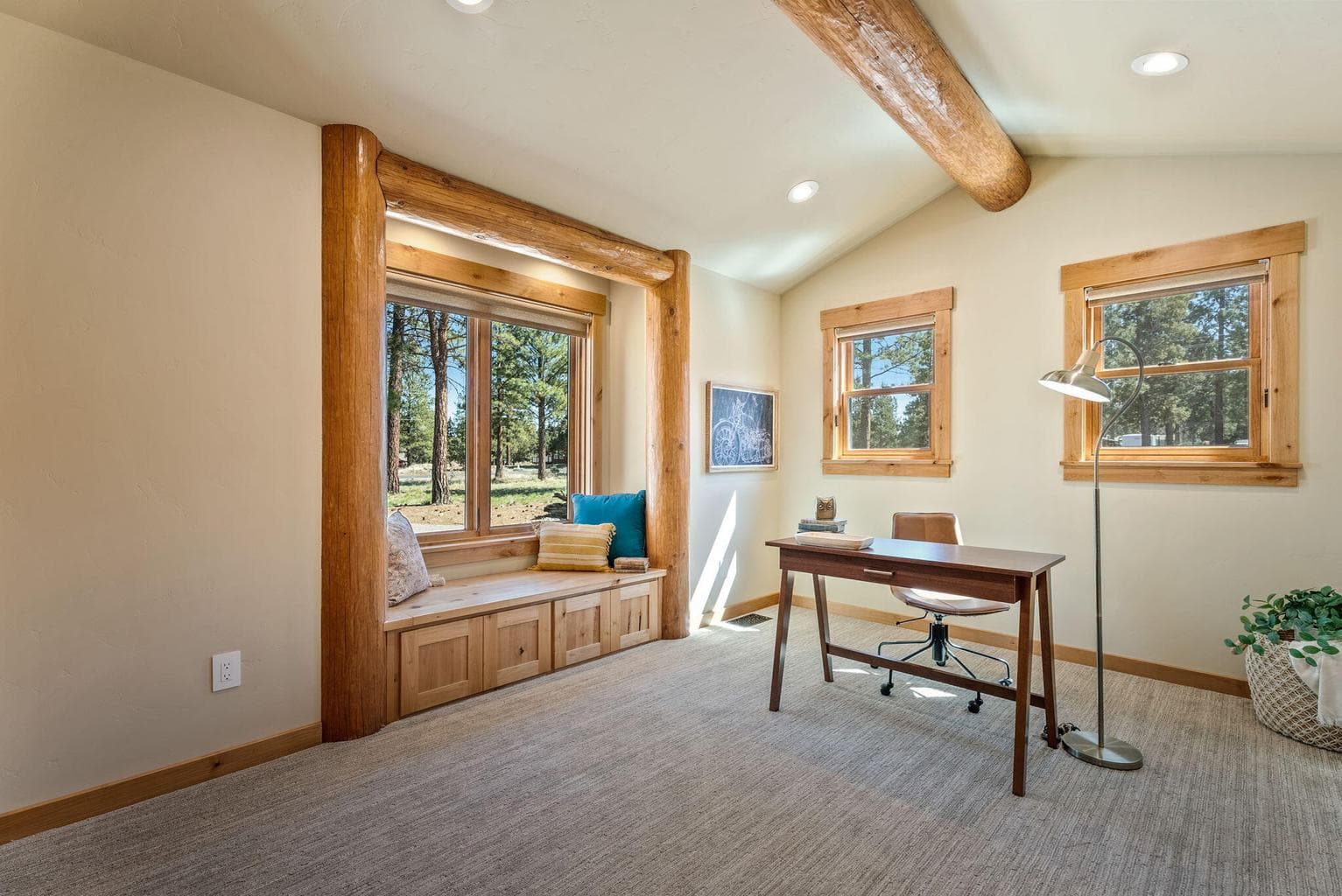 Guest bedroom features vaulted, log-beam ceiling, knotty alder reading nook with built-in storage, and large closet.