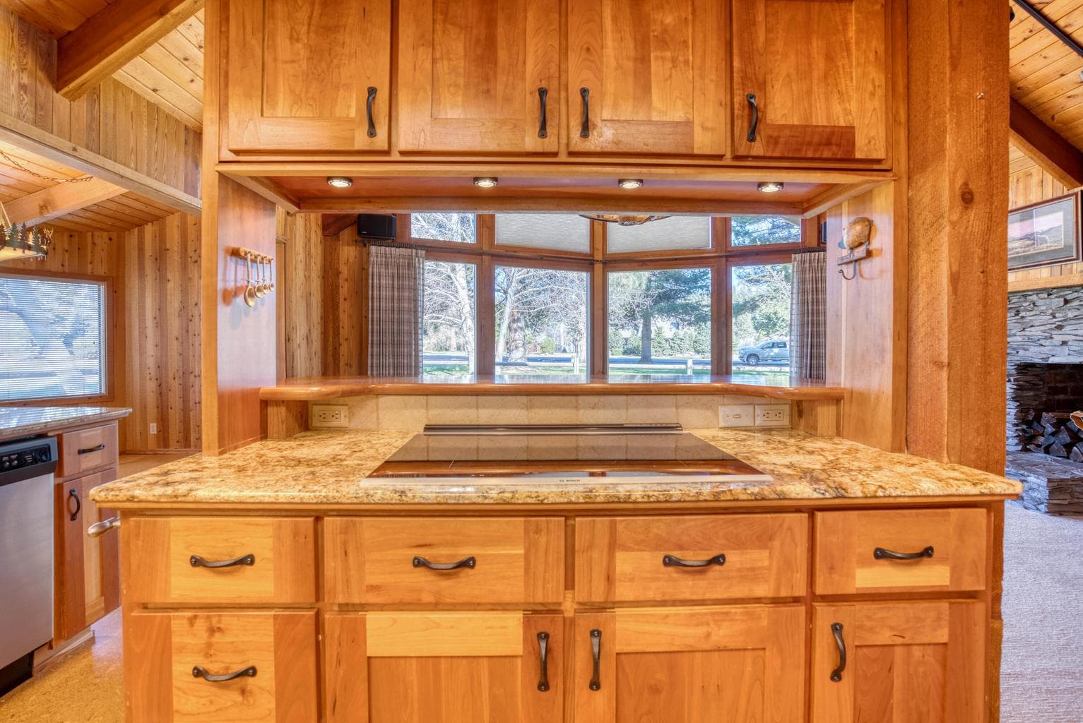 An induction range, granite countertop and eating bar seating.