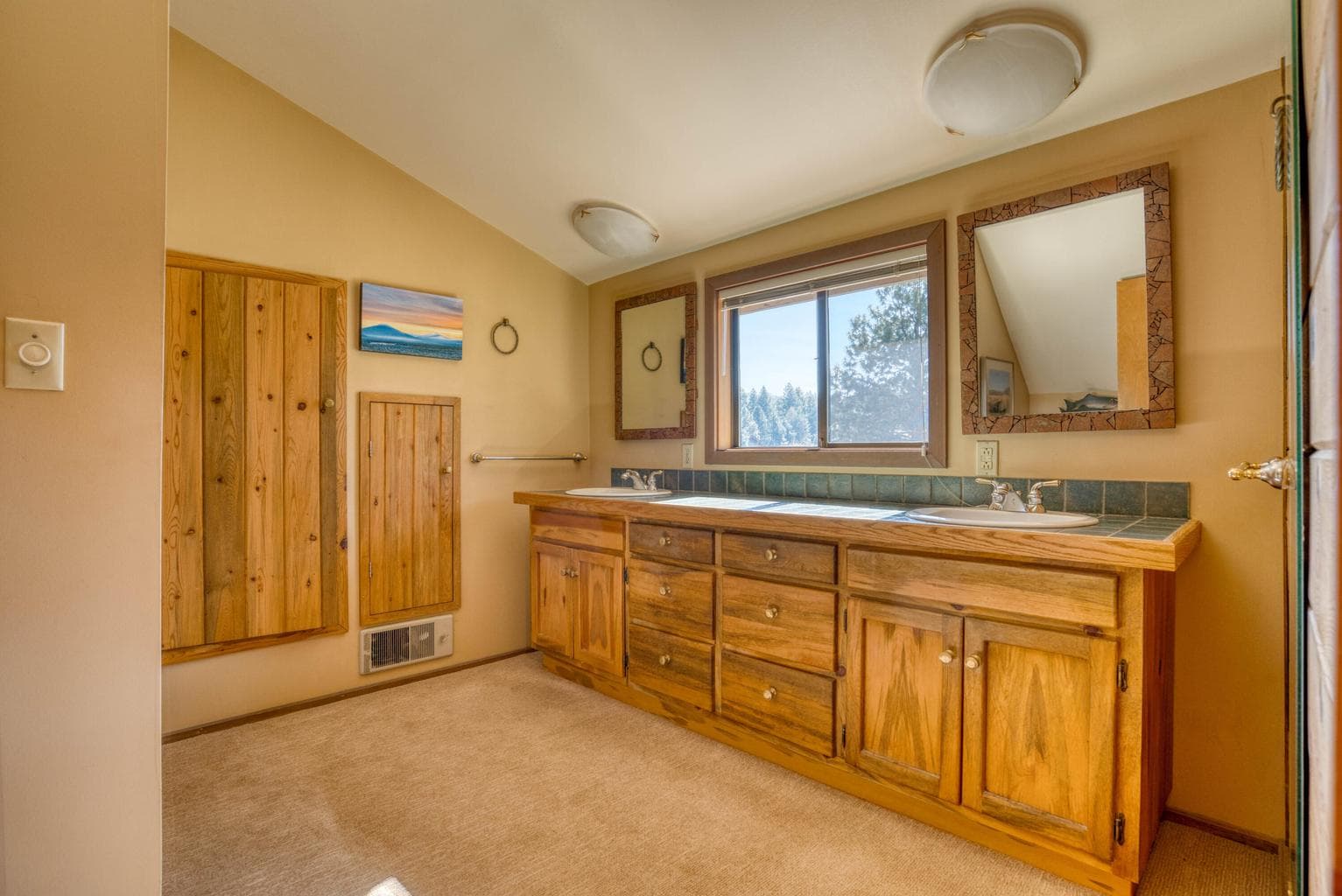 A double vanity, built-in storage and stall shower.