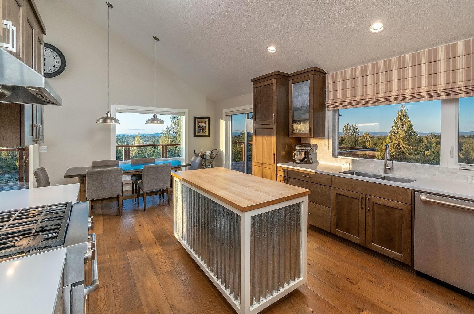 Inspiring mountain scenery is highlighted by clean quartz countertops and butcher block island for additional prep space.