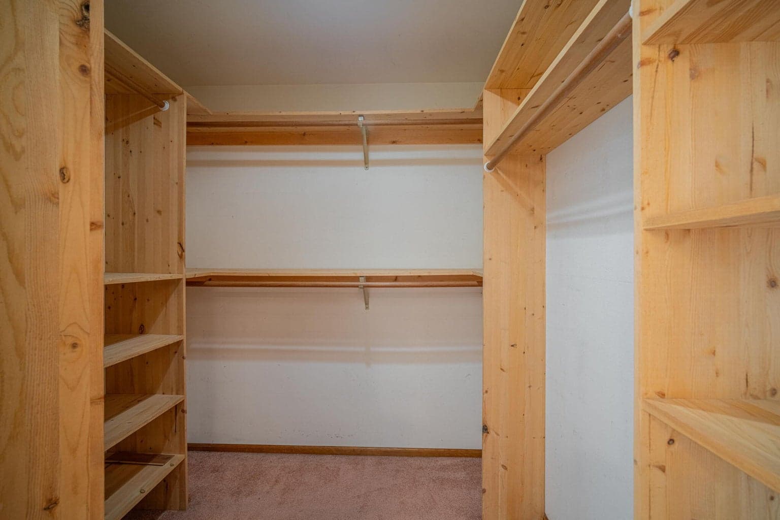 Primary walk in closet with custom built-ins