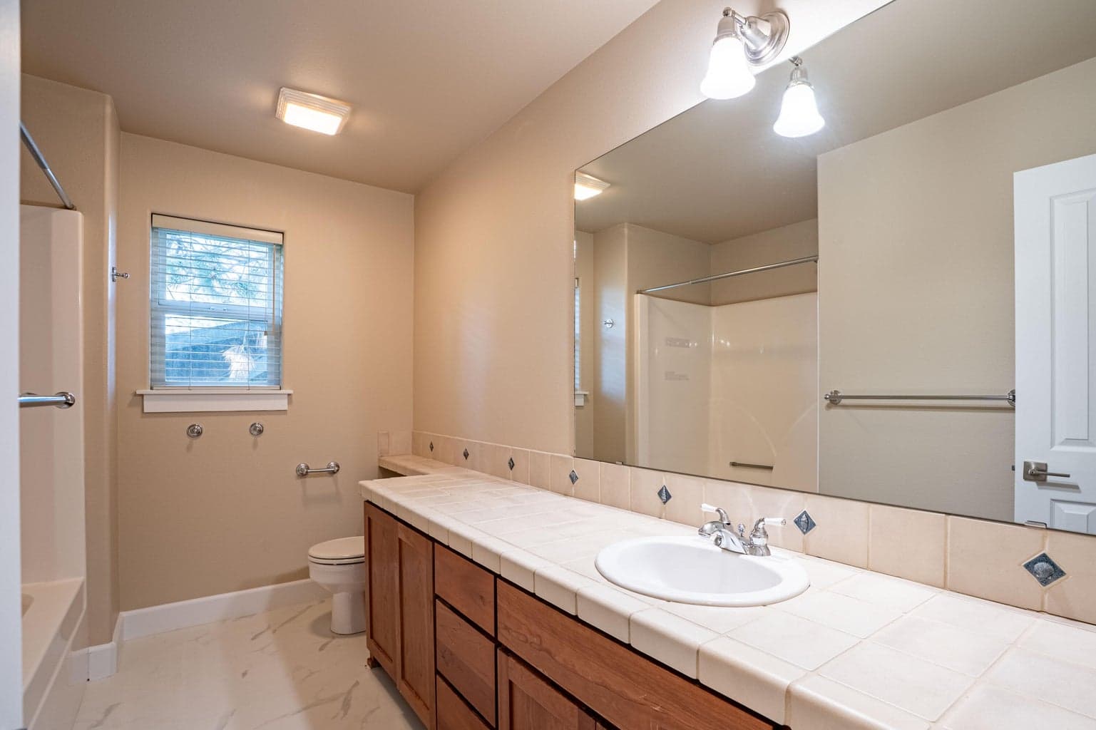 Hall bath offers a tub/shower, tile tops and updated LVT flooring