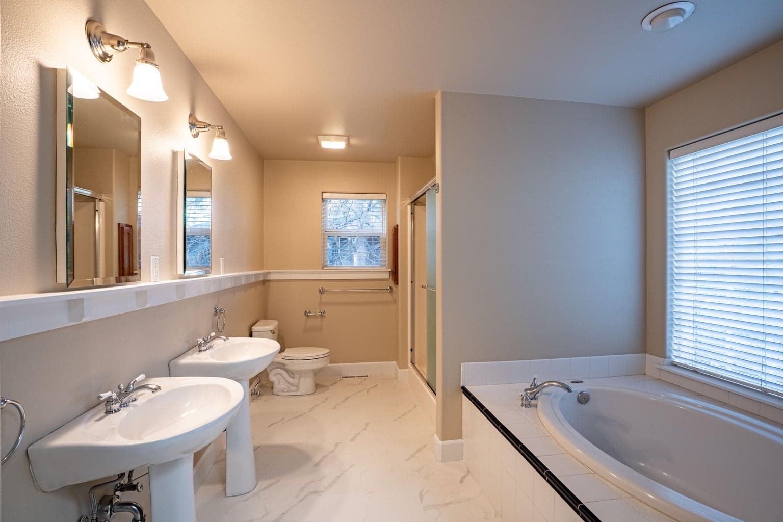 Primary bathroom, updated LVT flooring, double sinks, linen closet, soaking tub and step in shower