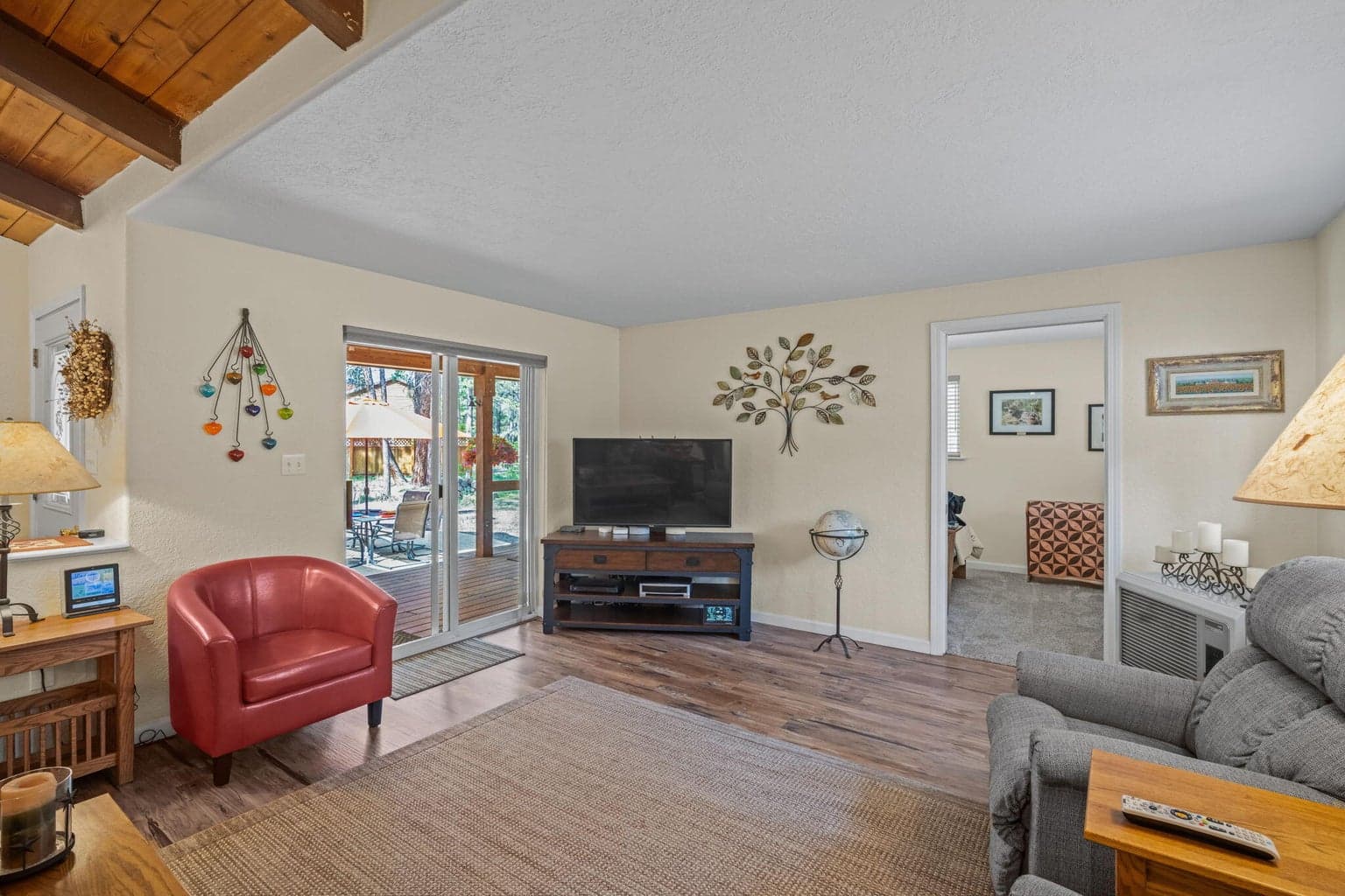 Living area with slider door access to the front porch. Third bedroom access.