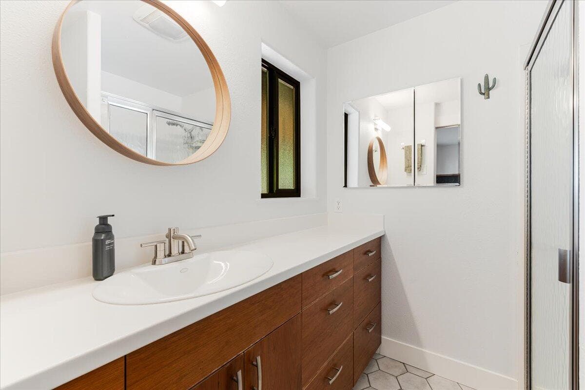 Primary bath with step in shower and extra long vanity and storage cabinet.