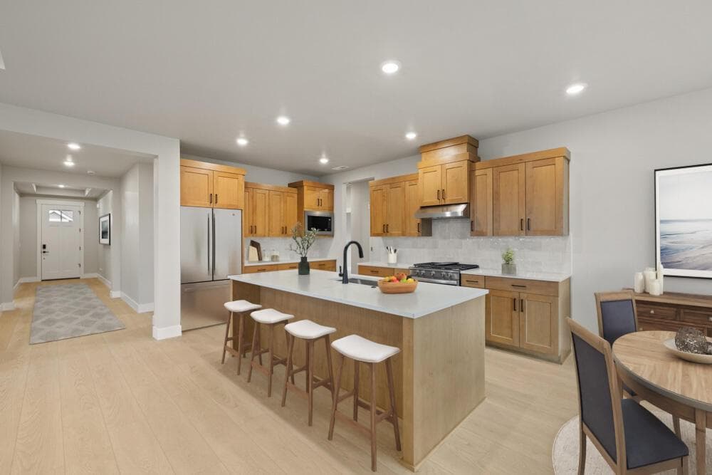 Virtual staging, subject property - Spacious kitchen and dining area in the open greatroom. Wide hallway to front entrance.