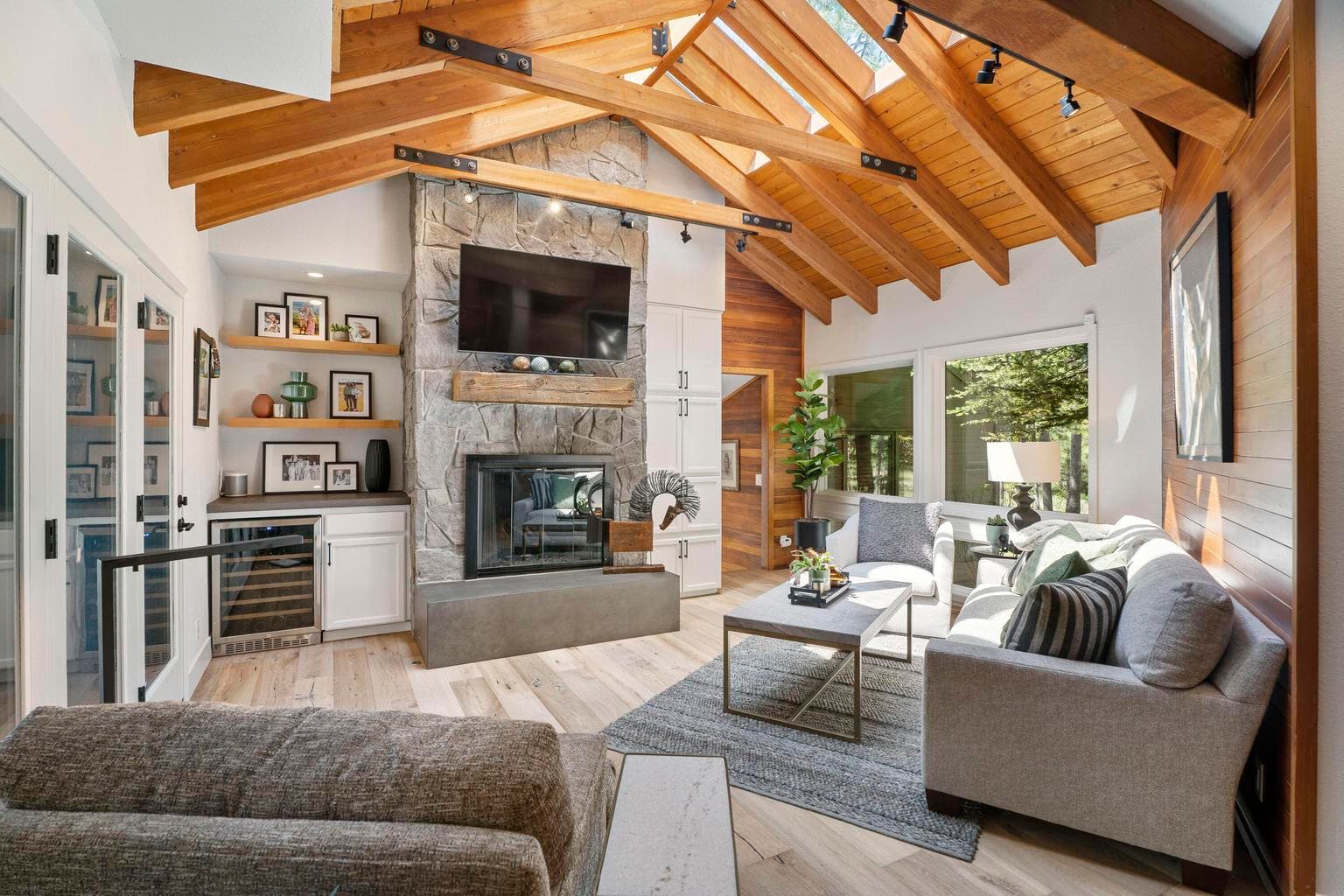 The family room features vaulted wood ceilings, open trusses, gas fireplace and bar with built in cabinets.