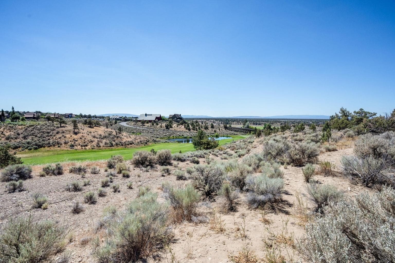 A street-level shot from the paved cul-de-sac shows the natural high desert landscape of the lot.