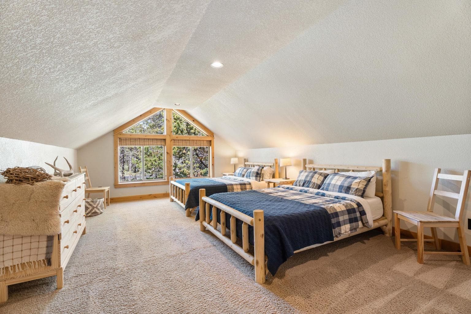 Spacious upstairs bedroom with vaulted ceilings—offering an airy, open feel and plenty of room to unwind.