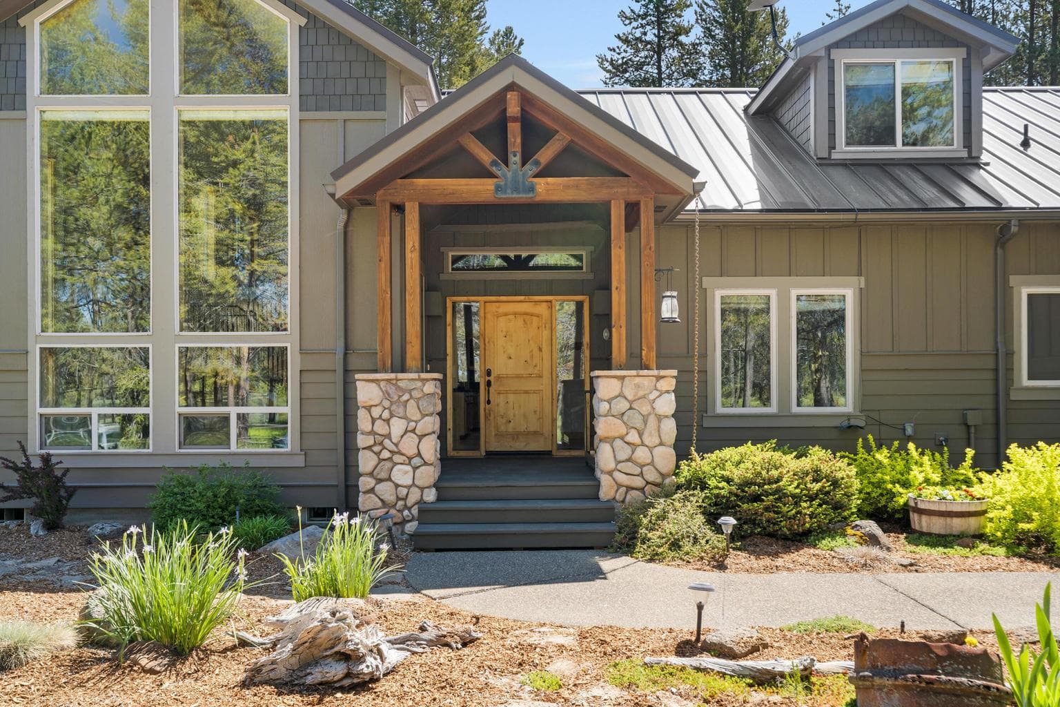 Grand stone columns and a rich wooden beam entry welcome you onto durable Trex decking—setting the tone for timeless curb appeal.