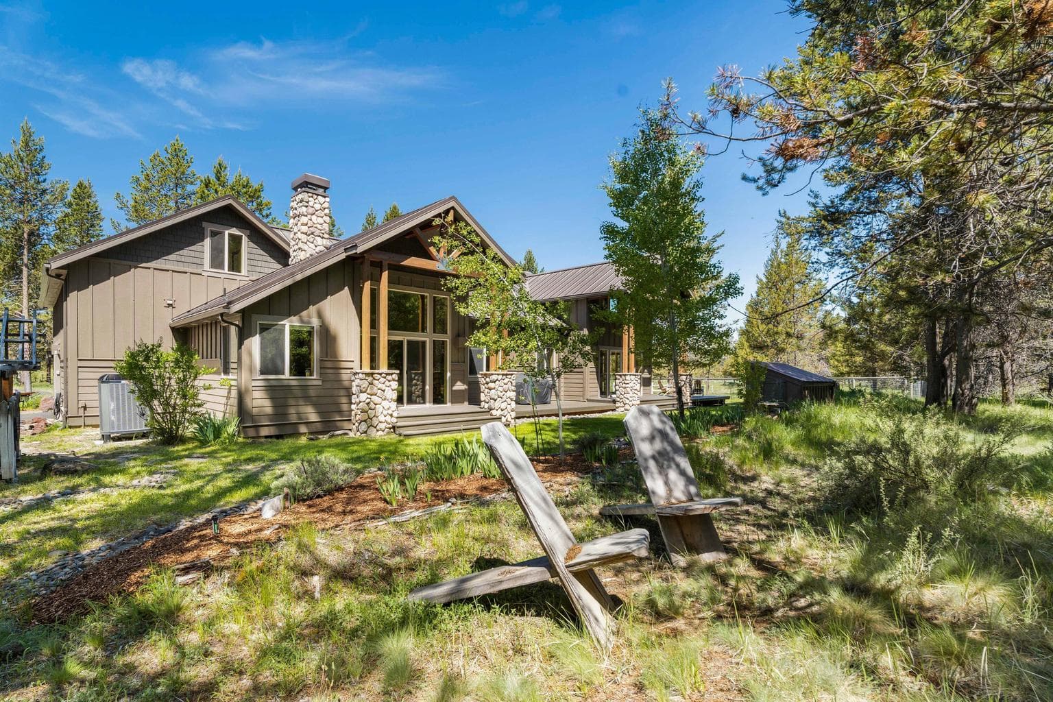 A stunning rear view showcases the craftsmanship of this custom home—where thoughtful design meets 360 degrees of natural beauty.