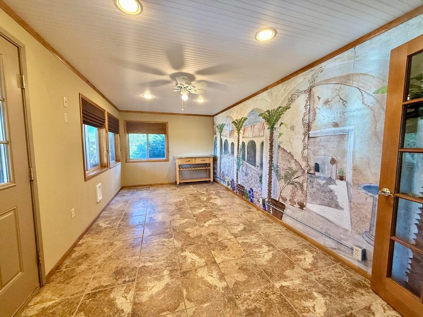 French doors lead to this cute area that used to be used as a small kitchenette. Has man door to back yard.