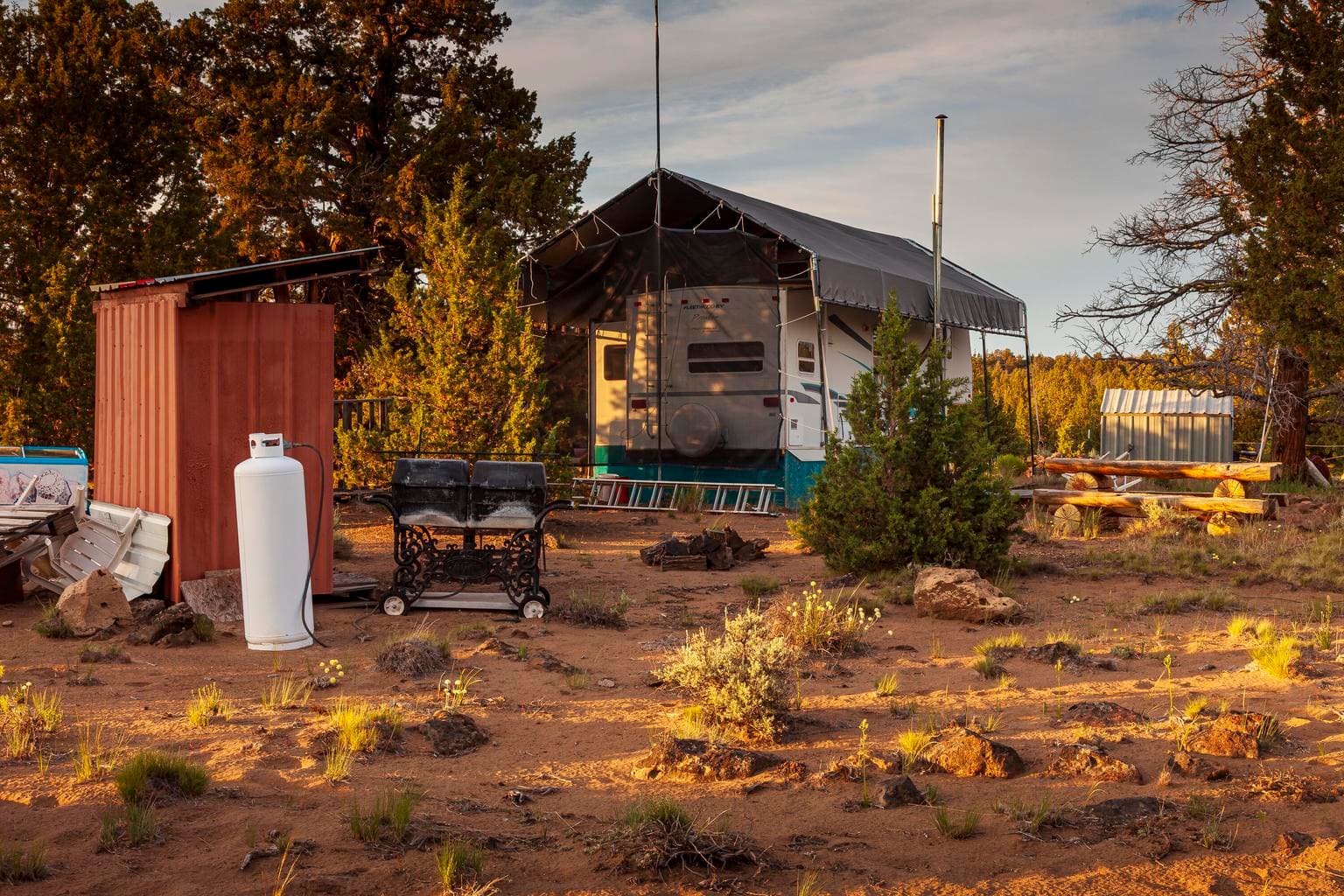Small storage structure, BBQ, propane tank 5th wheel, canopy, and Juniper log picnic table are included in sale.
