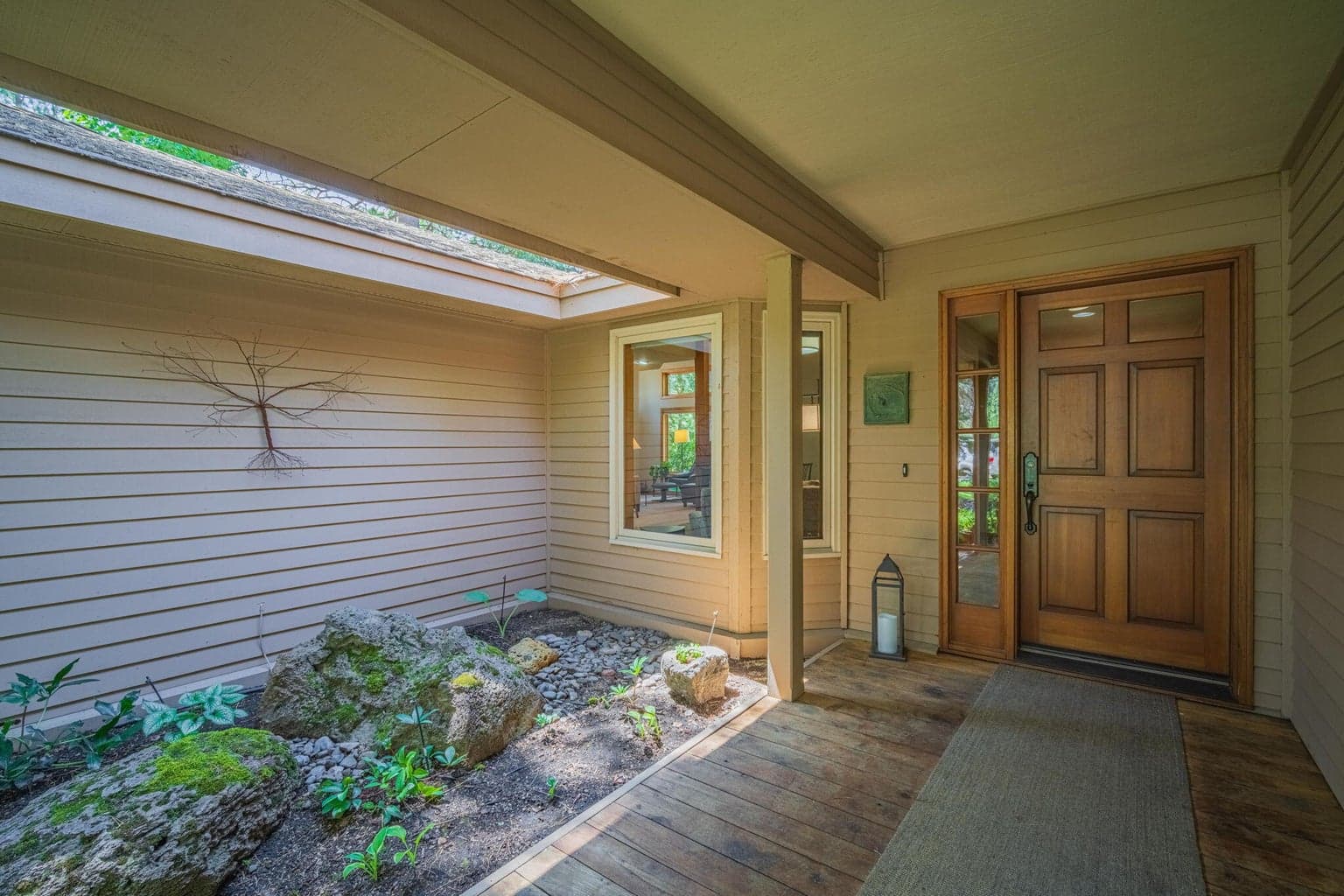 Front door enjoys a covered, front deck to get out of the elements with a border of additional landscaping.
