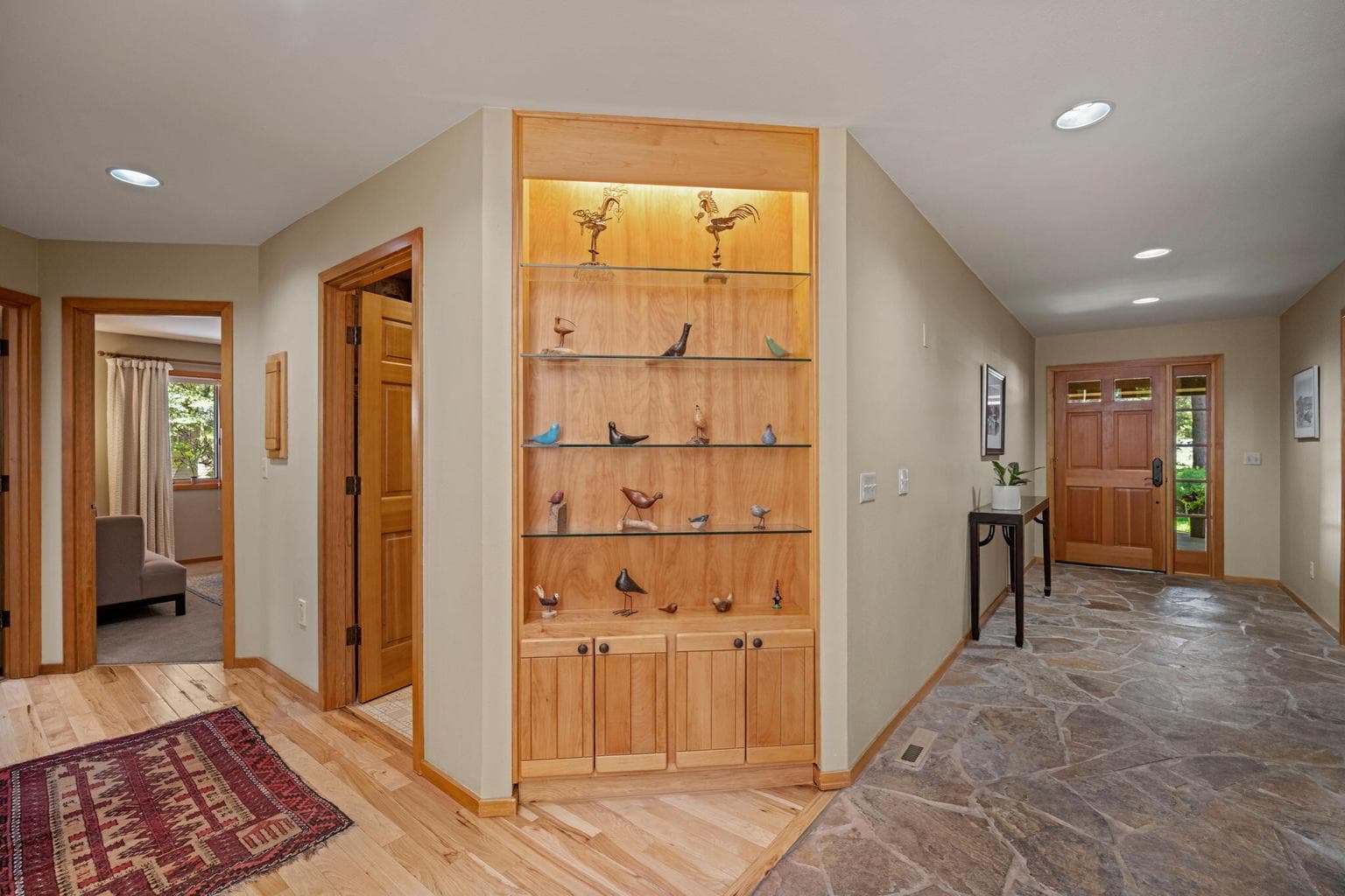 Interesting angles throughout the home, here featuring the confluence of the natural flooring of slate, wood and a built in curios cabinet.