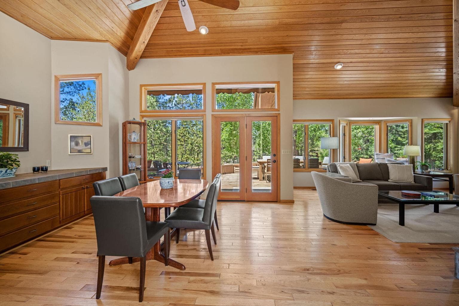 View towards the rear deck, lots of trees out in the distance, the dining area and adjoining living room enjoy lots of windows and natural light.