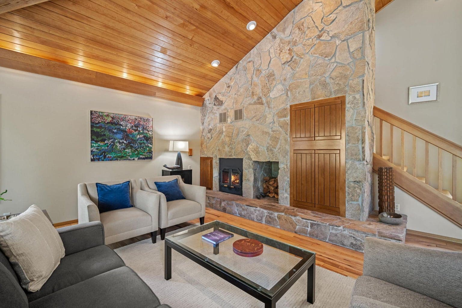 A wall of Ochoco stone, frames the hearth, wood burning fireplace and built in entertainment nook.