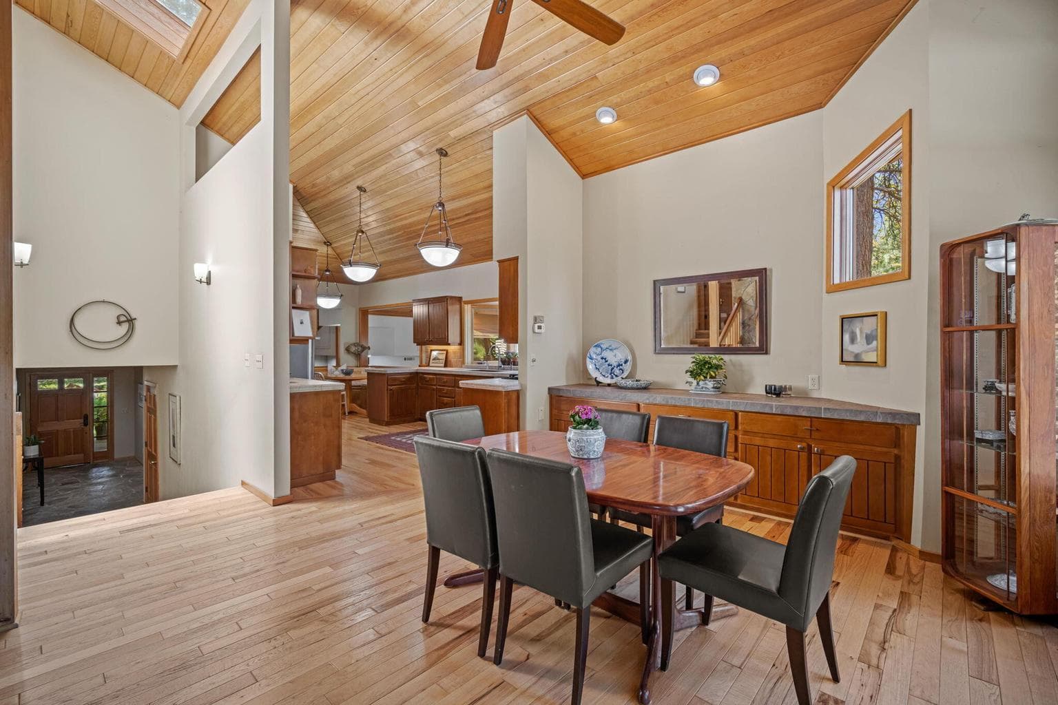 View of the vaulted great room, looking back towards the kitchen and dining from the living room area.