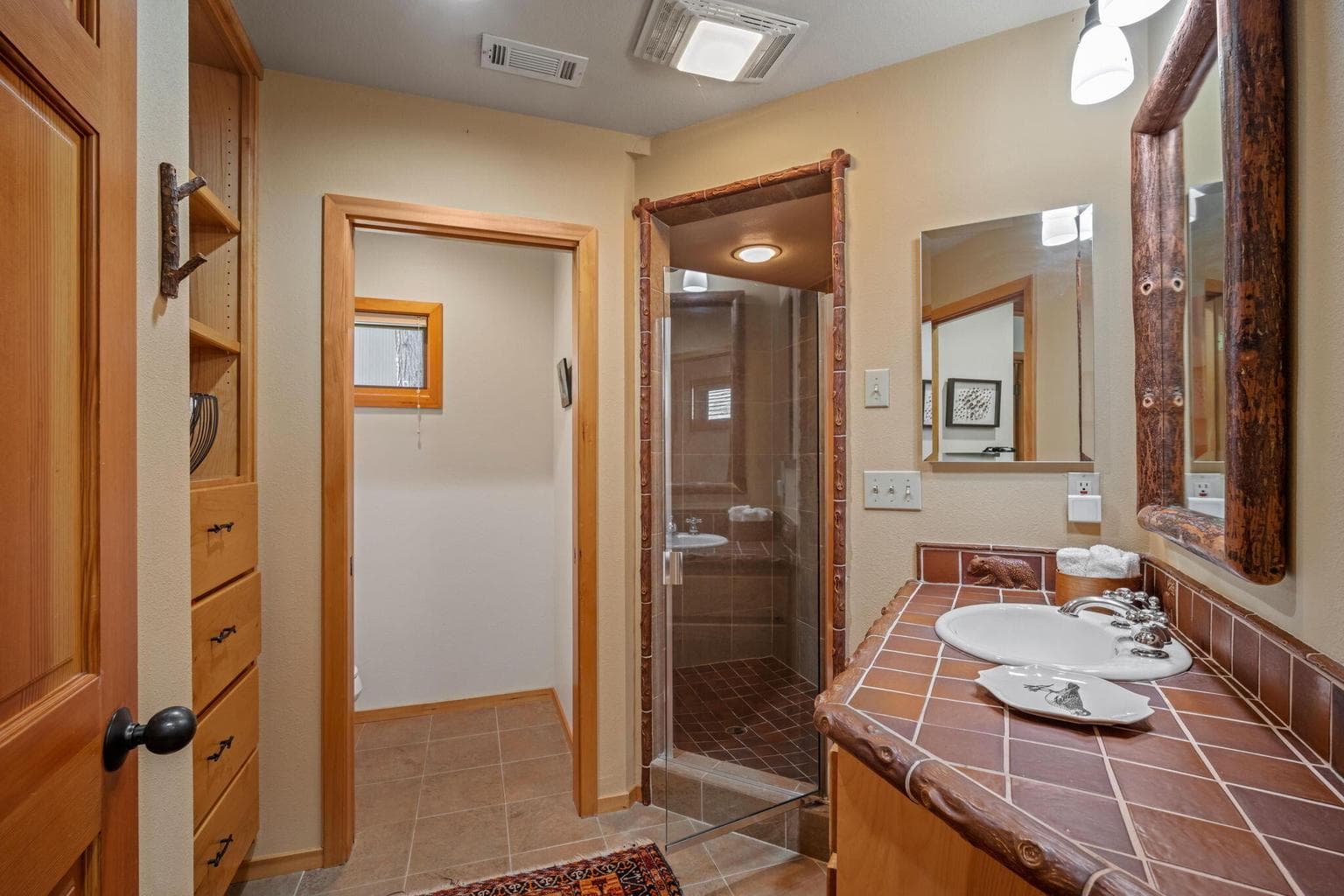 View from main level bath to the adjoining family room, built-ins for linens and storage.