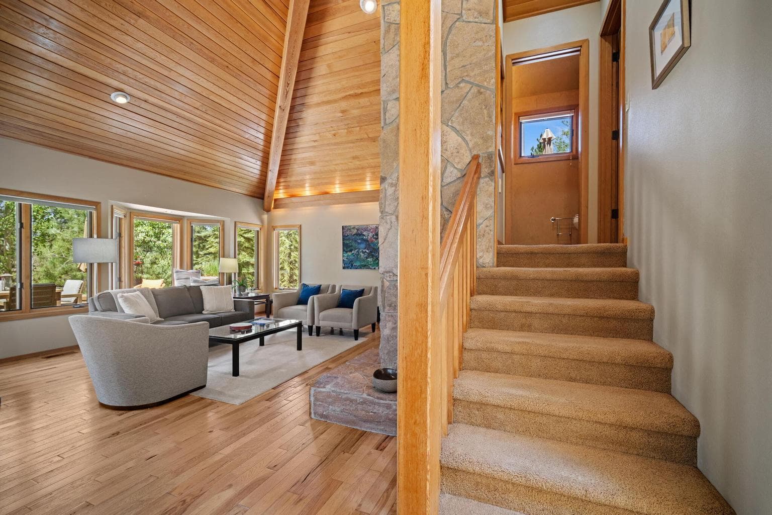 Stairs from the great room up to a powder bathroom and the primary suite is to the right.