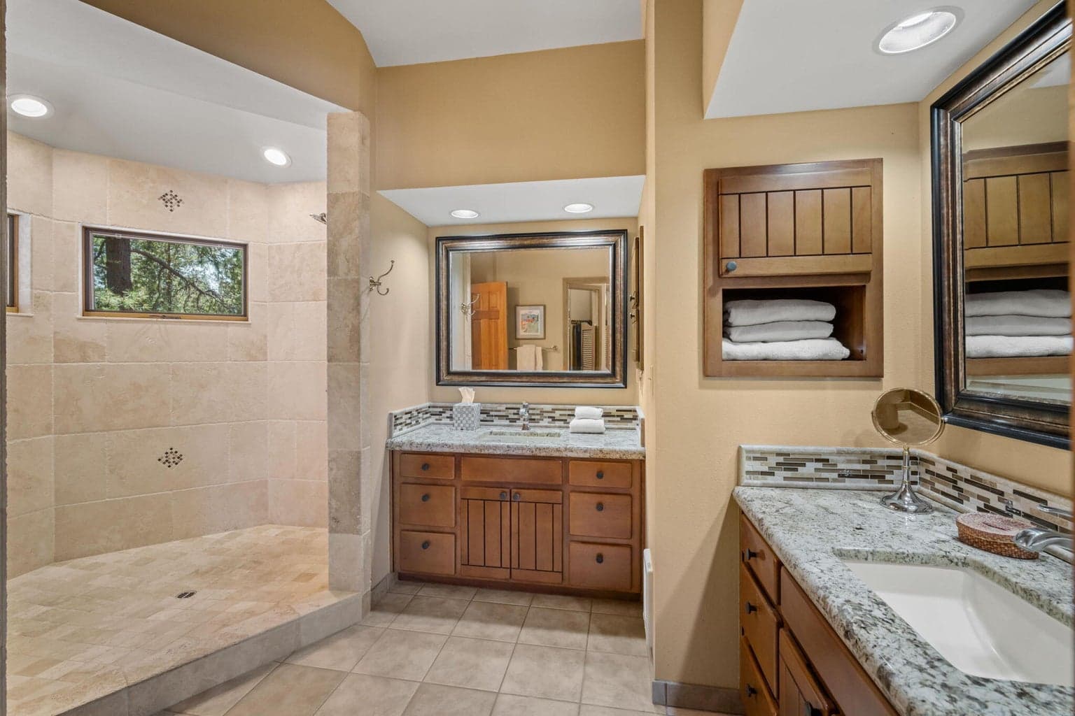 Primary bathroom is complete with two granite countertop vanities and a huge, step-in, travertine shower with 2 shower heads.