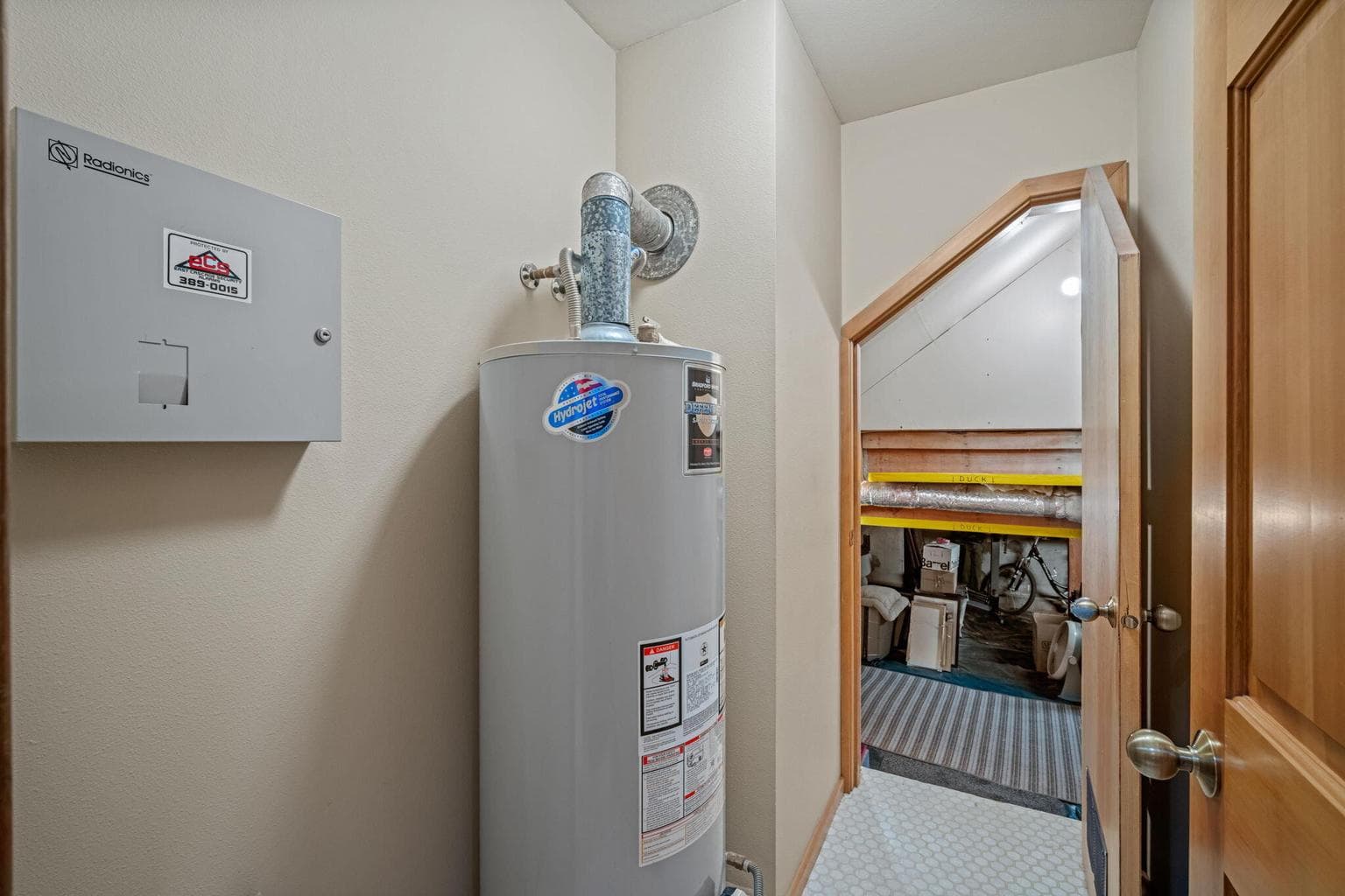 Utility closet with hot water heater and entrance to the unfinished basement; a huge opportunity for storage.