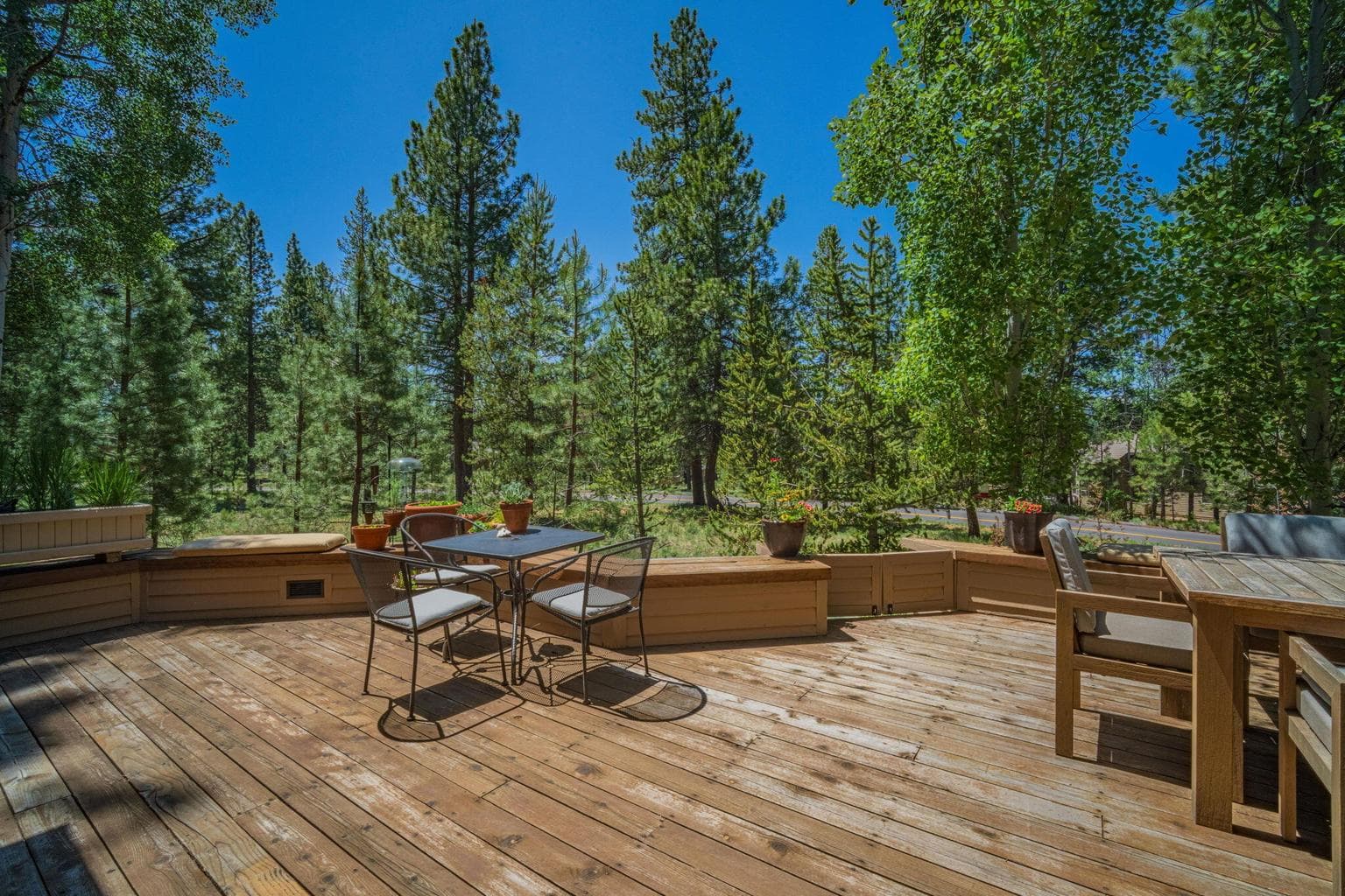 Back deck with built in seating and gate to walk down to a paver walkway to hot tub and back patio.