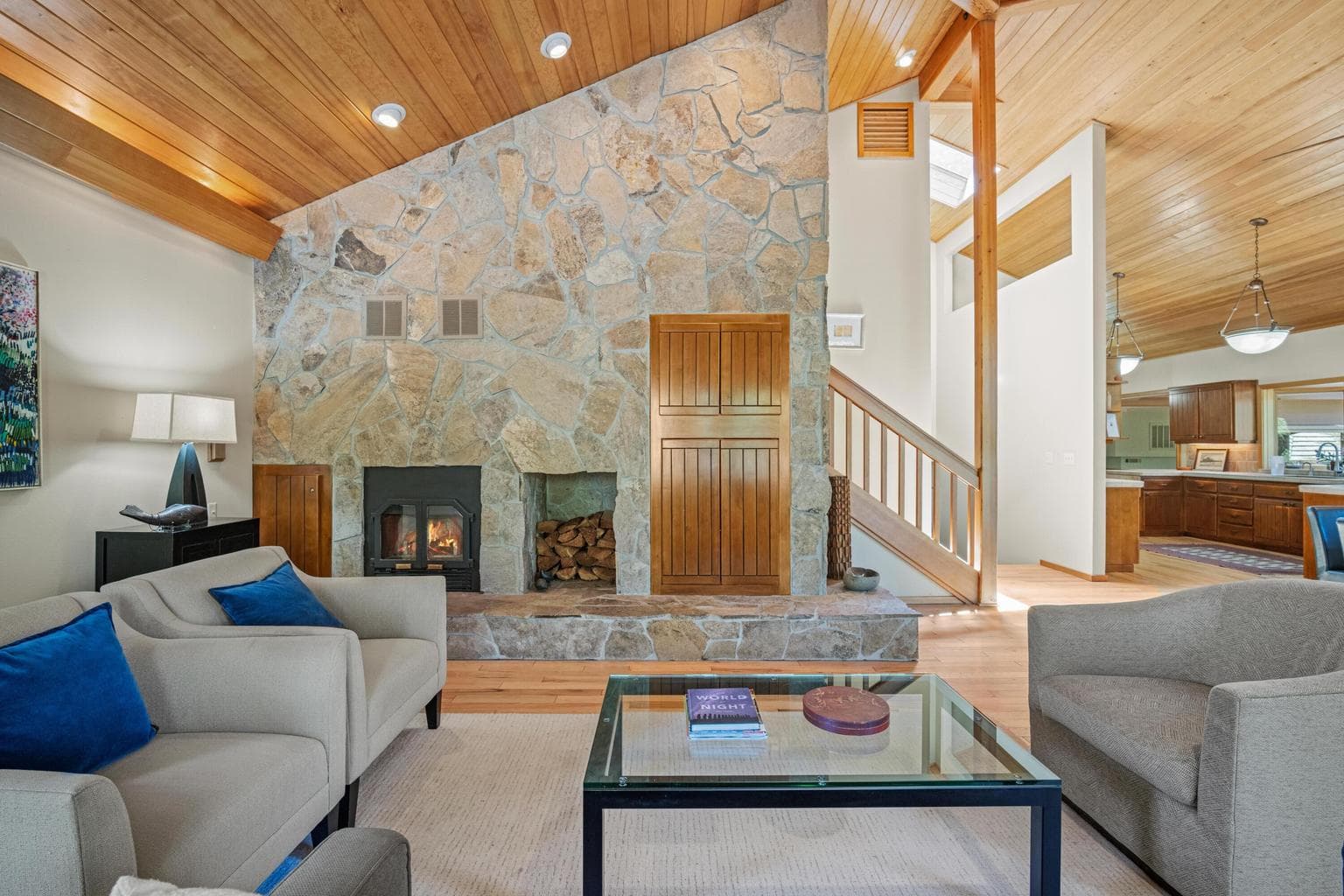 Living room area looking to the fireplace wall and stairwell up to the primary suite.