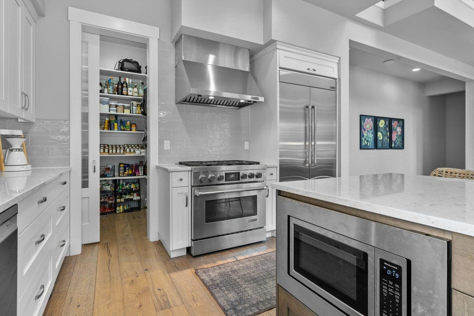 Commercial grade JennAir range, refrigerator and Bosch dishwasher plus walk-in pantry for additional storage.
