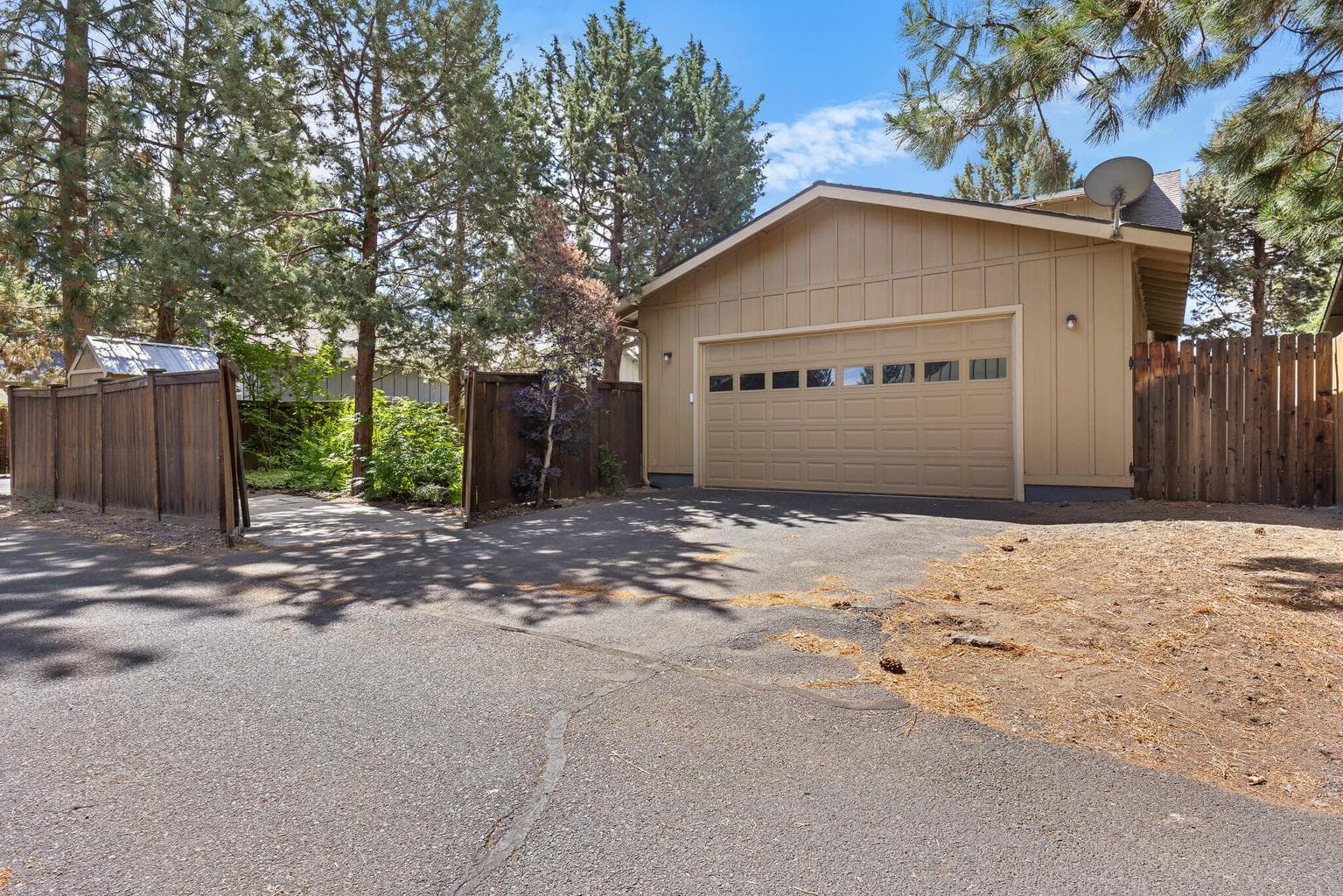 Rear alley garage access and gate leading to a concrete pad for small rv or boat