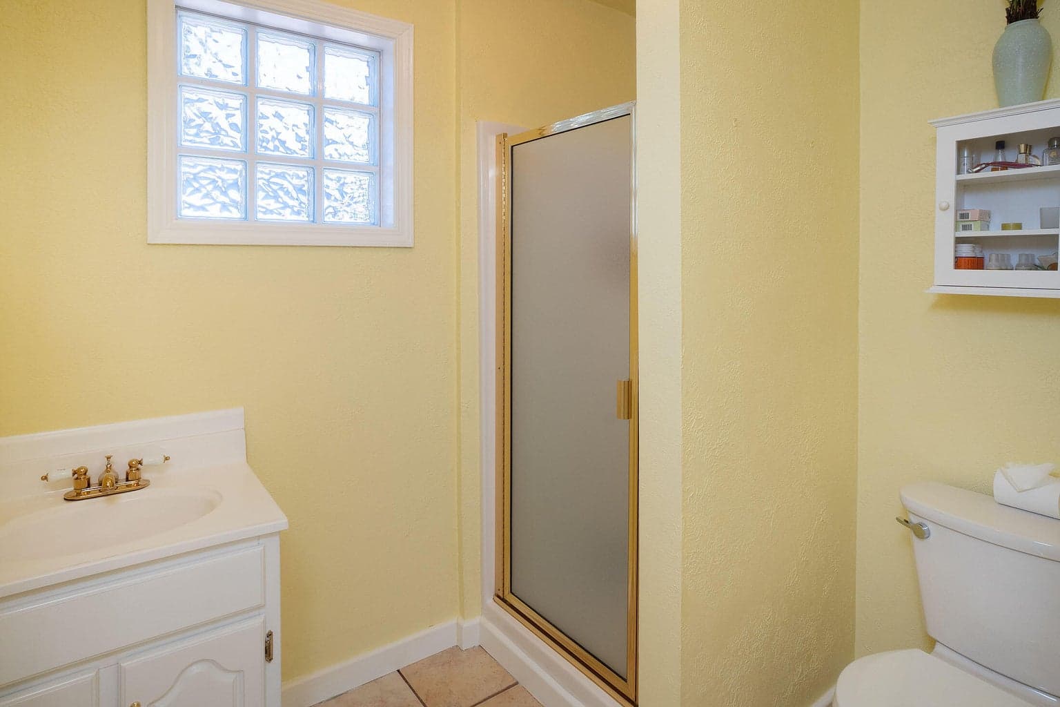 Bathroom in guest cottage with natural light, sink, vanity, shower.