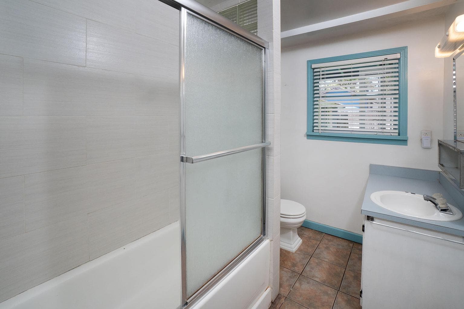 Bathroom is convenient to both bedrooms, has a full tub, and window.