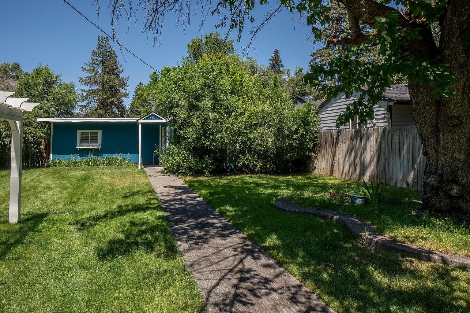Concrete walk welcomes you to this sweet cottage in Midtown Bend. Beautiful lawns and trees.
