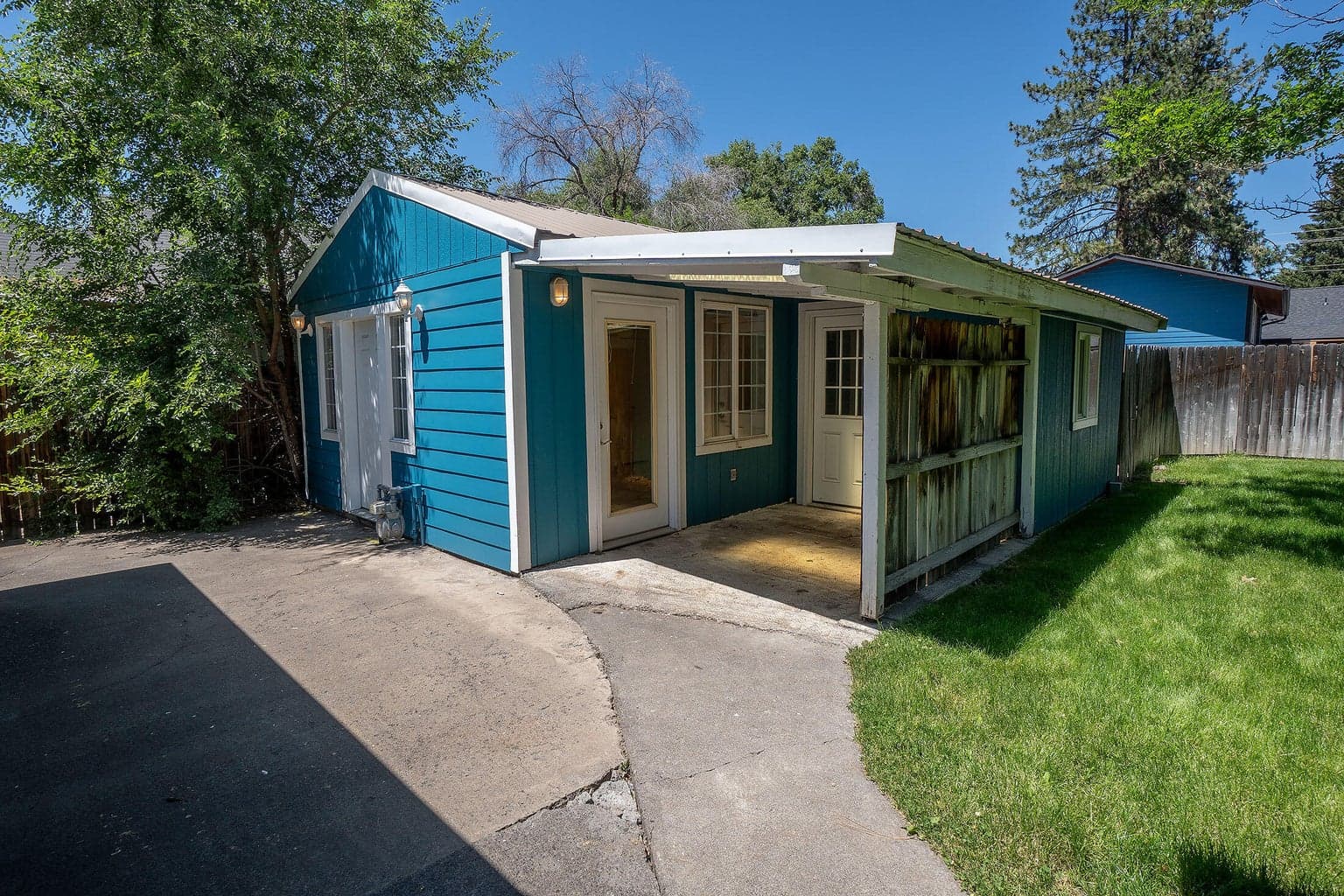 Studio guest cottage shown here with attached covered enclosed patio & entry to storage room. This is the side door, which you can use as main entry if desired. Cottage has 3 entries, not all necessary.